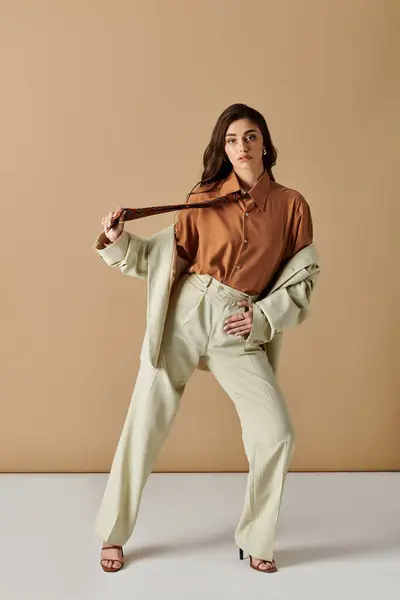 A stylish young woman exudes modern elegance in a chic suit within a studio. — Stock Photo