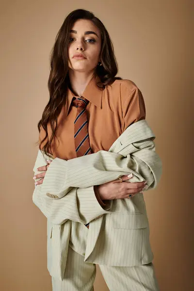 A fashionable young woman with long brown hair stands in a trendy studio, exuding elegance. — Stock Photo