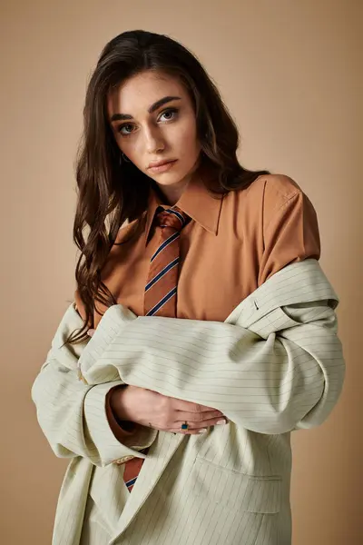 A beautiful young woman with long brown hair showcases a fashionable outfit in a studio environment. — Stock Photo