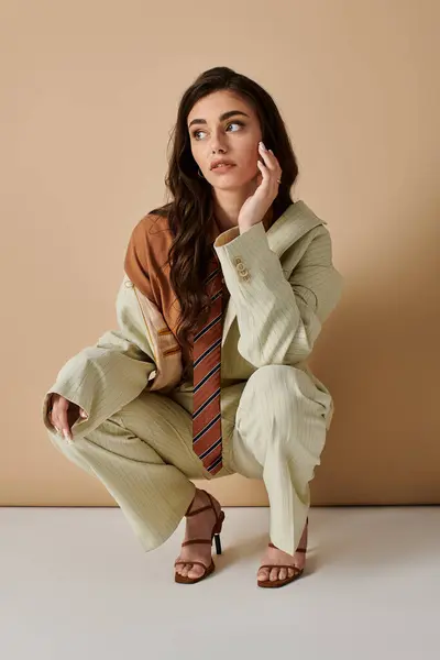 Young woman with long brown hair showcases modern fashion in elegant attire during a studio shoot. — Stock Photo