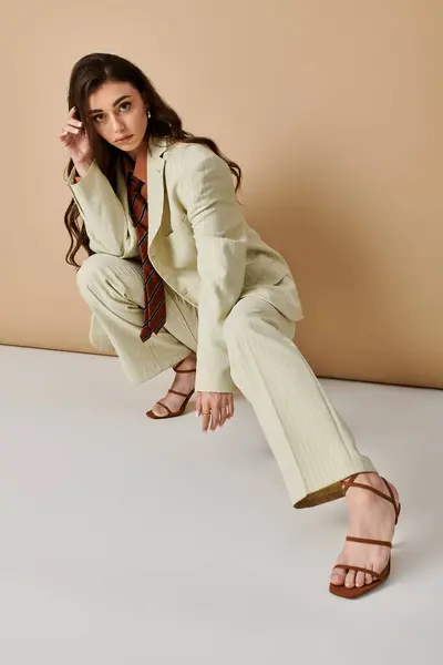 A beautiful young woman poses elegantly in a fashionable suit and tie, exuding confidence. — Stock Photo