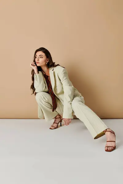 A young woman with long brown hair poses in a fashionable suit and tie — Stock Photo