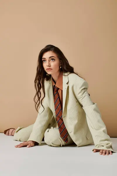 A beautiful young woman poses in a fashionable suit with a tie, exuding confidence and style. — Stock Photo