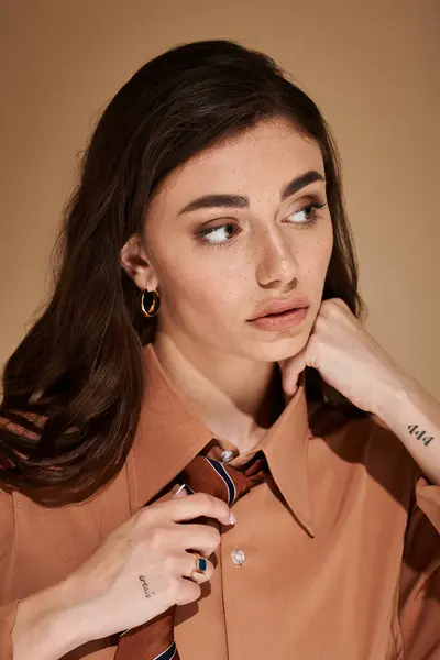 A stunning young woman with long brown hair poses elegantly in stylish, modern fashion. — Stock Photo