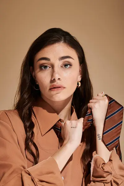 A beautiful young woman poses confidently in fashionable attire, emphasizing her stylish tie. — Stock Photo
