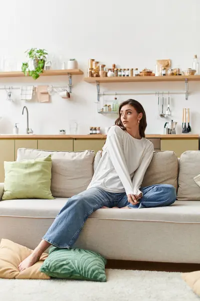 A beautiful young woman with brown hair relaxes in casual clothes, savoring tranquility at home. — Stock Photo