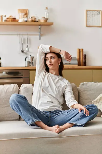A young woman with brown hair enjoys quiet time, relaxing comfortably in her apartment. — Stock Photo