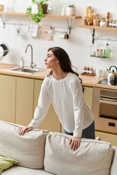 Young woman with brown hair takes a break at home, savoring calm in her apartment space. — Stock Photo
