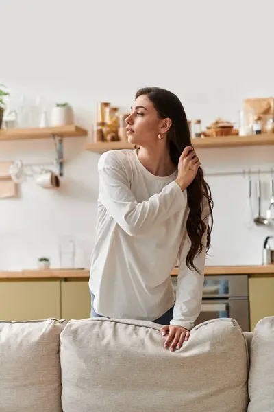 A young woman with brown hair relaxes in casual clothes at home, enjoying tranquility. — Stock Photo