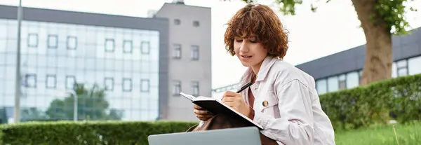 Curly-haired woman enjoys a sunny summer afternoon working remotely in a lush park setting, banner — Stock Photo