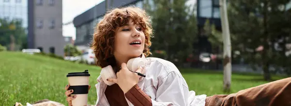Curly-haired woman relaxes with coffee and headphones in summer, banner — Stock Photo
