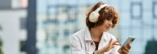Curly-haired woman relaxes in the park while listening to music, banner — Stock Photo