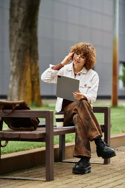 Freelancer enjoys a sunny summer day working on a tablet in a vibrant green park. — Stock Photo