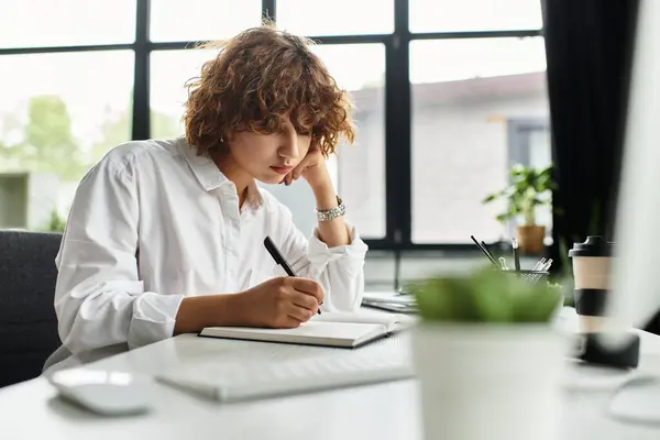 A young businesswoman with curly hair writes notes in her modern office during summer. — Stock Photo