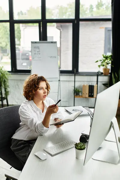 Curly-haired businesswoman analyzes strategies at her desk in a contemporary office setting. — Stock Photo
