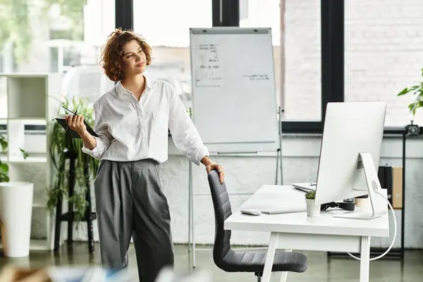 A young businesswoman with curly hair works attentively in a modern office setting. — Stock Photo