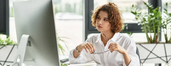 Curly-haired businesswoman engages thoughtfully in her tasks at a contemporary office this summer, banner — Stock Photo