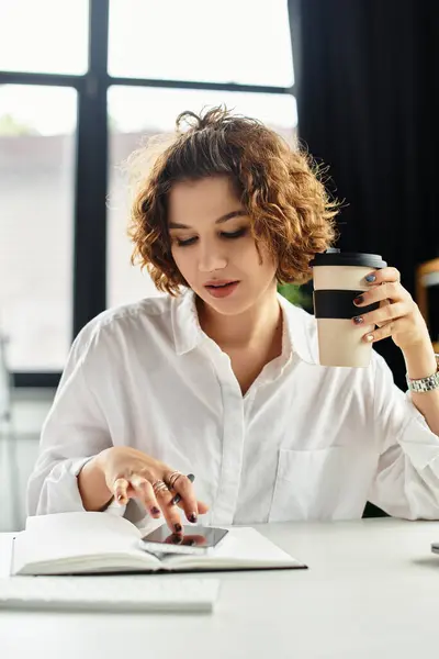 Curly-haired businesswoman works focused at her desk, balancing tasks and coffee during summer. — Stock Photo