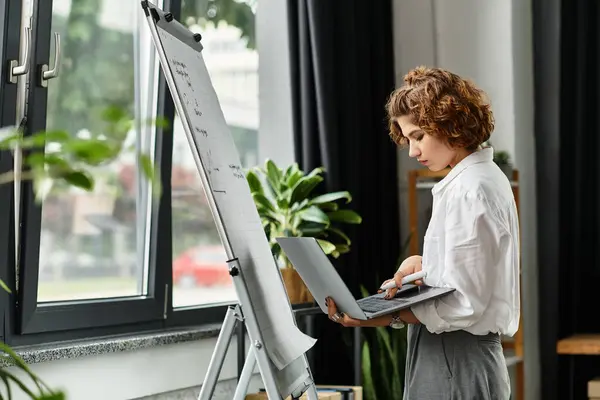 Young woman in smart casual attire engages with her laptop while brainstorming ideas. — Stock Photo