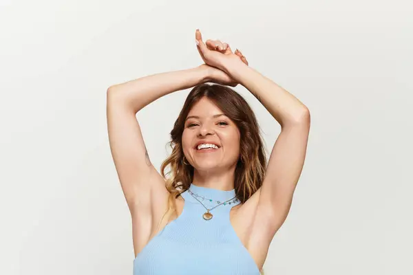 Bright summer day finds a young woman radiating joy, arms raised in celebration of life. — Stock Photo