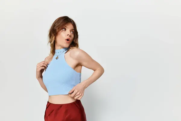 A young beautiful woman presents a playful atmosphere, showcasing her summer fashion and charisma. — Stock Photo