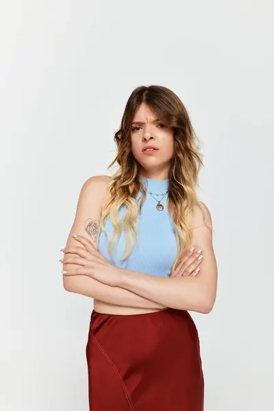A confident young woman in a stylish crop top and skirt exudes summer vibes. — Stock Photo