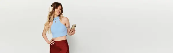 A young beautiful woman radiates summer vibes while smiling and checking her smartphone. — Stock Photo