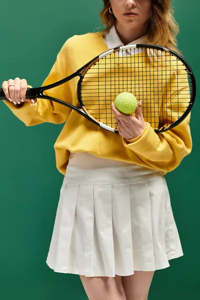 Young woman in a bright sweatshirt holds a tennis racquet and a ball, radiating summer energy. — Stock Photo