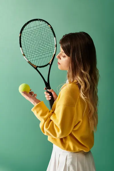 Bright space with a woman in yellow holding a tennis racket and ball, exuding summer vibes. — Stock Photo