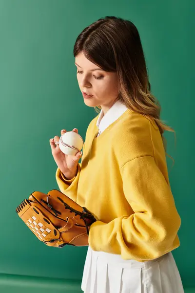 A young woman in a yellow sweater and white skirt holds a baseball and glove, exuding summer cheer. — Stock Photo