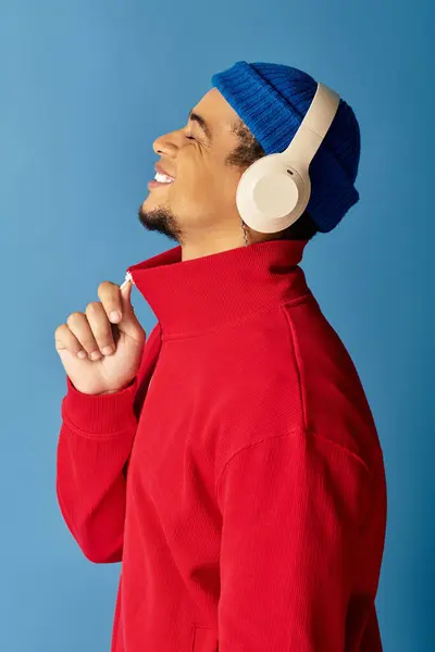 Трогательный молодой человек с улыбкой во время прослушивания музыки. — стоковое фото