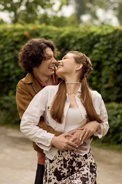 Young couple embraces each other warmly, sharing smiles and love during a walk in nature. — Stock Photo