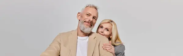 A loving senior couple embraces, showcasing their romance and connection in stylish outfits. — Stock Photo