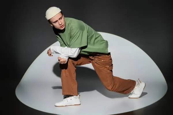 Young man dressed in trendy outfit displays confidence and style while striking a dynamic pose. — Stock Photo