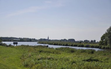 Hollanda, IJssel (Overijssel) üzerinde, 25-8-2022, çayırlardan geçerek Hatem şehrine doğru nehir 