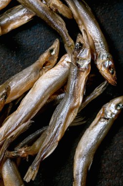 Kurumuş deniz balıkları koyu dokulu arka planda hamsa ançüezi kokardı. Tuzlu geleneksel aperatif. Deniz ürünleri geçmişi