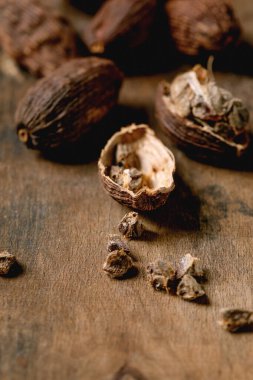 Siyah kakule ve tohumlar koyu ahşap masada. Sağlıklı beslenme, baharatlı yemek malzemeleri, Asya mutfağı.