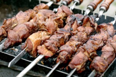 Izgarada pişen sulu ızgara et şişleri. Terbiye edilmiş et parçaları kızgın kömürlerin üzerinde metal şişler üzerinde kızarıyor. Geleneksel BBQ pişirme yöntemi.