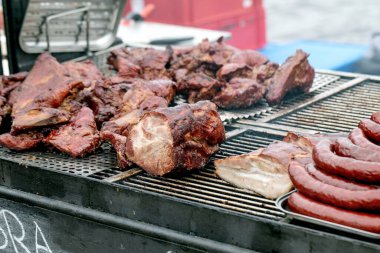 Sulu ızgara et ve ızgarada pişen sosisler. Çeşitli pirzolalar ve domuz barbeküsü. Açık havada yaz pikniği konsepti.