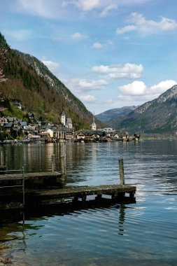 Güzel Hallstatt Alp köyü manzarası, göl kenarında ahşap iskele ve Alpler 'deki popüler Avusturya turizm merkezi kilise kulesi..