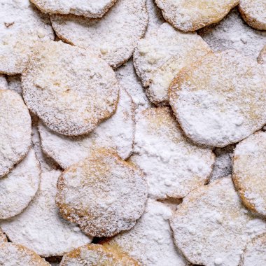 Pudra şekerli ev yapımı kurabiye, yemek arkaplanı. Gerçek bir köy tatlısı, beyaz ekmek kağıdında ev yapımı hamur işi. Üst görünüm, kapat