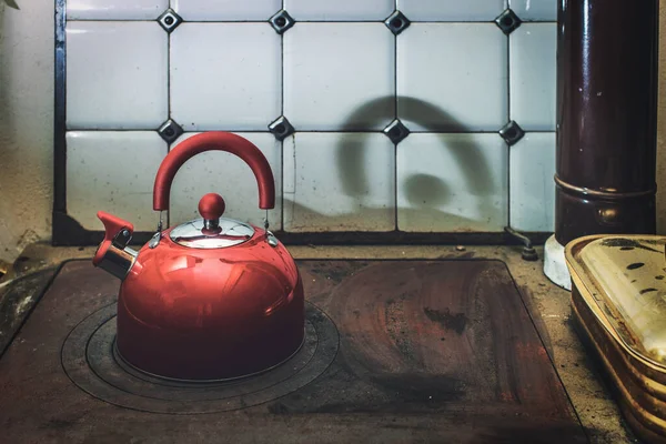一个现代茶壶在古老便宜的厨房炉灶之上 — 图库照片