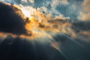 Divine rays of sun in the sky between the clouds clipart