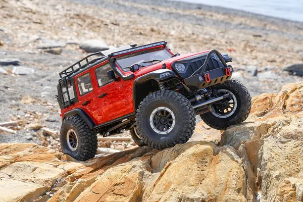 Radyo kontrollü model araba kayaya tırmanıyor..