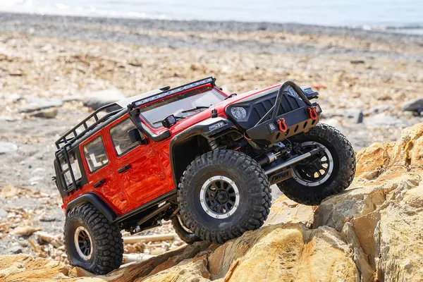 Radyo kontrollü model araba kayaya tırmanıyor..