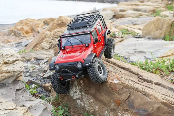 Radyo kontrollü model araba kayaya tırmanıyor..