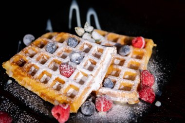 Delicious waffles with raspberries on table, closeup. High quality photo