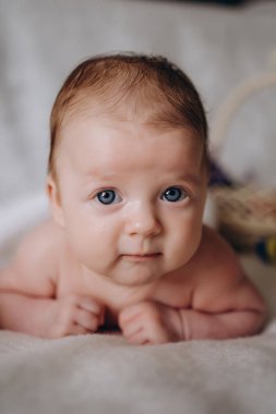 Paskalya 'da küçük şirin bir bebek. Sarı ve mavi paskalya yumurtaları yakınlarda. Kameraya bakar ve gülümser. Ukrayna. Barışçıl Paskalya konsepti. Yüksek kalite fotoğraf