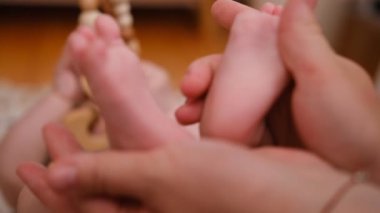 Bebek ayakları annenin ellerinde. Minik Yeni Doğmuş Bebek 'in ayakları, Kadın Kalp Şeklinde Eller, yakın plan. Annesi ve çocuğu. Mutlu Aile kavramı. Anneliğin güzel kavramsal videosu. Yüksek kalite 4k görüntü