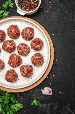 Çiğ köfte, kıyılmış domuz eti, beyaz tabakta koyu arka plan. Mutfak, yemek pişirme konsepti. Yemek tarifi geçmişi. Kapat..